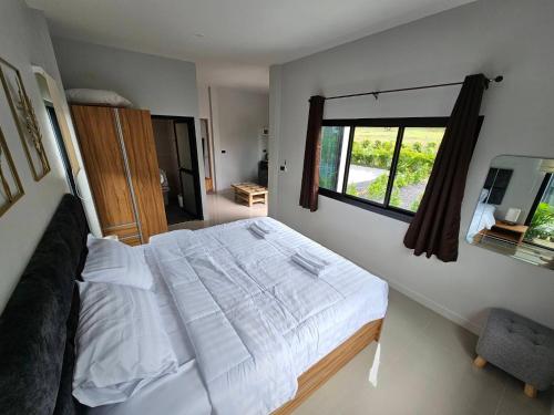 a bedroom with a large bed and a window at The Hill resort Thalang in Phuket Town