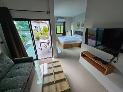 a living room with a couch and a flat screen tv at The Hill resort Thalang in Phuket Town