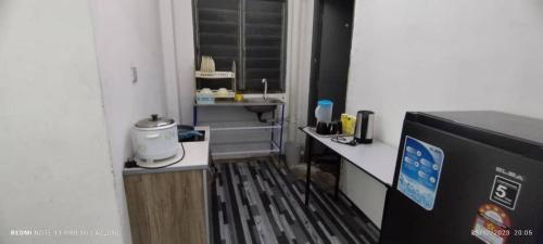 um quarto com uma cozinha com um balcão e um frigorífico em MY HOMESTAY PANGSAPURI SUTERA 2 em Kampong Telok
