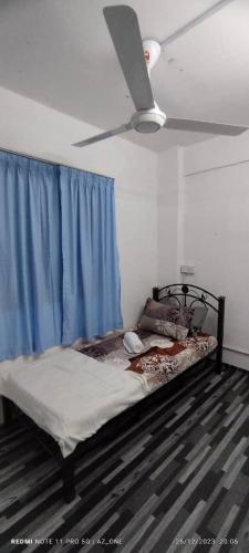 um quarto com uma cama com uma cortina azul em MY HOMESTAY PANGSAPURI SUTERA 2 em Kampong Telok