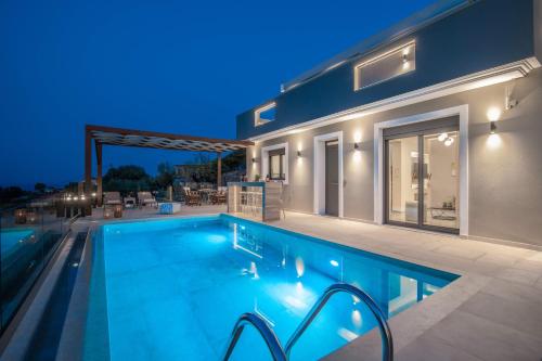 a swimming pool in front of a house at night at Lazai Villa in Zakynthos
