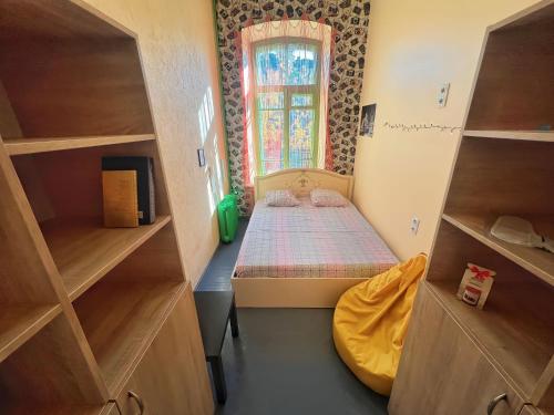 a small bedroom with a bed and a window at Vorobey Hostel in Kyiv