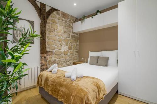 une chambre avec un grand lit avec des serviettes dessus dans l'établissement Typical Parisian Studio in Le Marais#4 pers, à Paris