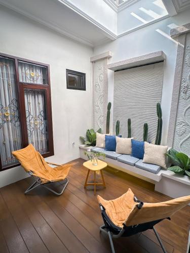 a living room with two chairs and a couch and cactus at Hening Pool Residence in Purwokerto