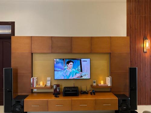 a room with a tv on a wall at Hening Pool Residence in Purwokerto
