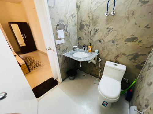 a bathroom with a toilet and a sink at ATULYAM HARSHADA STAYS LUCKNOW in Goshainganj