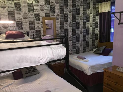 a room with two bunk beds and a wall with a wallpaper at Bradleys Hotel in Blackpool
