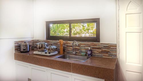 a kitchen counter with a sink and a window at EspIliNorte, Stay and Play in San Juan