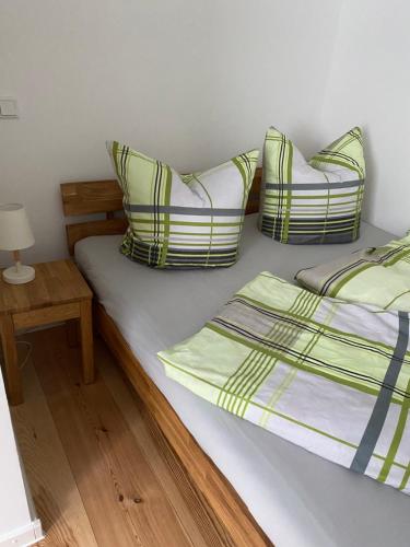 a bed with two pillows and a table with a lamp at Altstadt-Apartment Kirchblick in Gransee