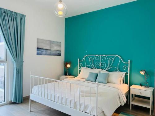a bedroom with a bed with a blue wall at Full Canal View Apartment at Yas Island- Brand New in Abu Dhabi