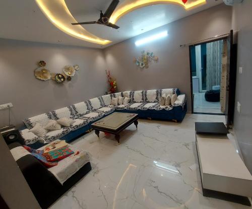 Sala de estar con sofás y mesa de centro en Aradhyas Stay en Jaipur