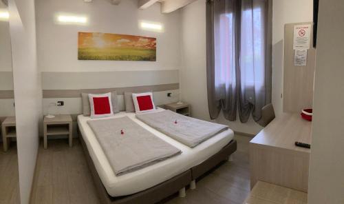 a hospital room with a bed with two red pillows at B&B Nuova Ostiglia in Quinto di Treviso