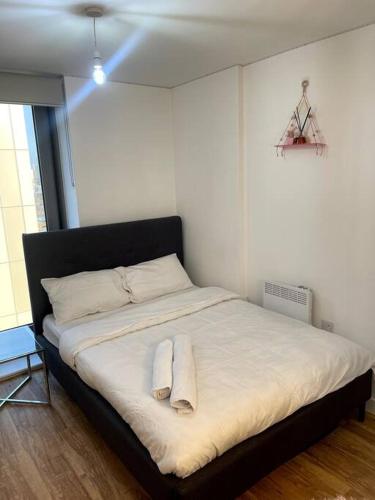 ein Schlafzimmer mit einem Bett mit zwei Handtüchern darauf in der Unterkunft Cozie 1 BR apartment in Manchester