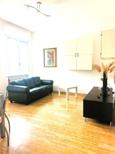 a living room with a black couch and a table at Appartamento Gioia Lugo a 5m da Maria Cecilia Hospital in Lugo