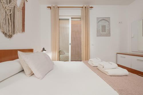 1 dormitorio con 1 cama blanca y 2 toallas en C55 Cosy studio close to the beach, en Málaga