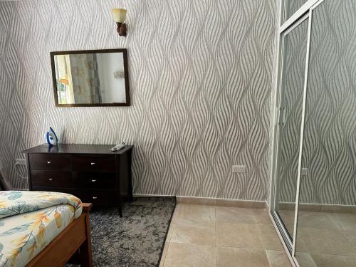 a bedroom with a shower and a mirror on a wall at Masaki - 2 Bedroom Apartment in Dar es Salaam