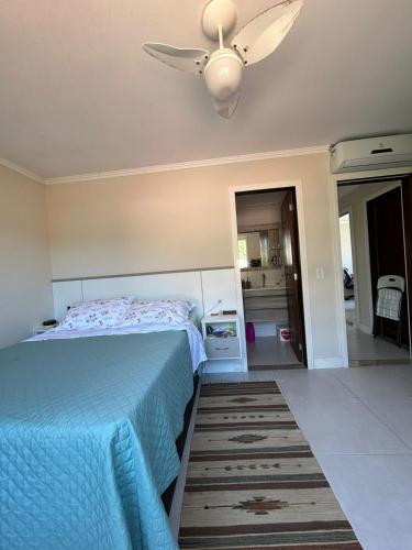Schlafzimmer mit einem Bett und einem Deckenventilator in der Unterkunft Suíte privativa - Praia do Canto Grande, Bombinhas in Bombinhas