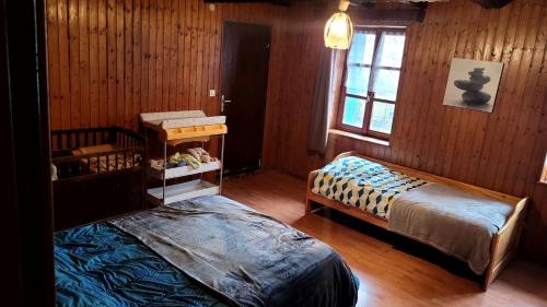 1 dormitorio con 2 camas y ventana en Maison De Vacances A Freconrupt en La Broque
