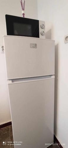a white refrigerator with a microwave on top of it at Karancs Apartman Salgótarján in Salgótarján