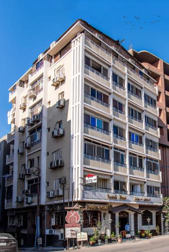 a large white building on the side of a street at Assiutel in Asyut