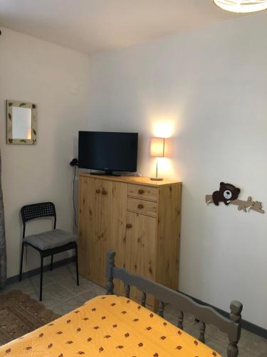 um quarto com uma cama e uma televisão num armário de madeira em Le Cigalou em Sainte-Croix-de-Verdon