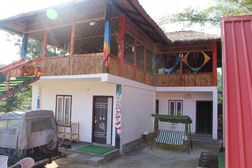 a small house with a balcony and a deck at Changmai's Inn kaziranga in Kāziranga