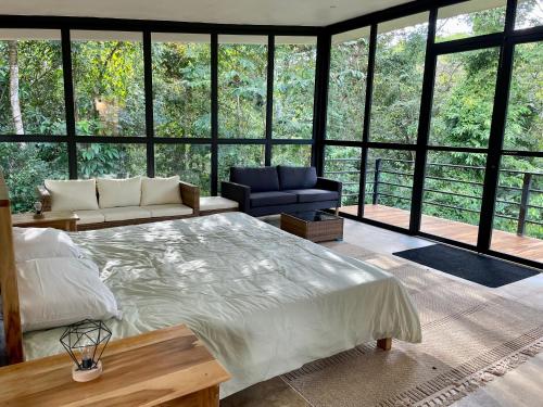ein Schlafzimmer mit einem großen Bett und einem großen Fenster in der Unterkunft Cascada Elysiana in Platanillo