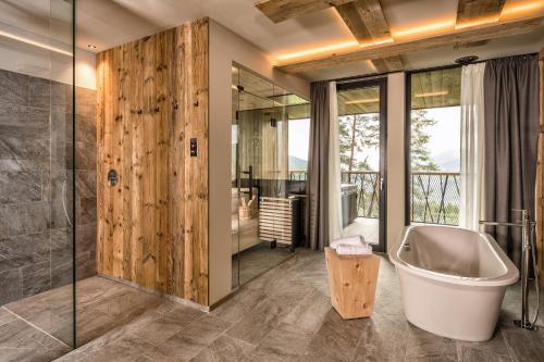 a bathroom with a tub and a walk in shower at My Arbor - Plose Wellness Hotel in Bressanone