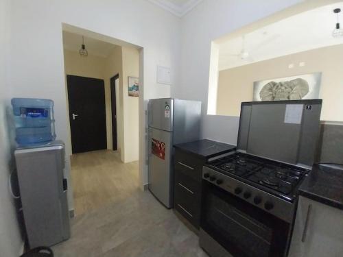 uma cozinha com um fogão e um frigorífico em Eleganza Suites em Kilifi