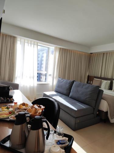 a living room with a couch and a bed at Tryp by Wyndham Brasília Nações in Brasilia