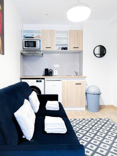 un salon avec un canapé bleu et une cuisine dans l'établissement Appart 4pers#1 Bedroom#République#Paris 3, à Paris