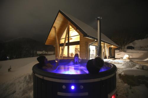 a couple of people in a hot tub in the snow at PORTAL WYSOWA in Wysowa-Zdrój