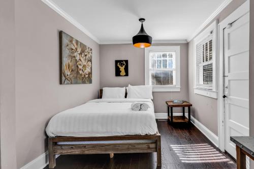 a bedroom with a bed and a pendant light at Bright and Modern Close to Everything in Charlotte