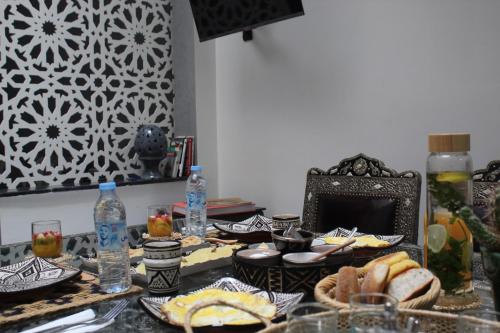 een tafel met borden en flessen water bij Riad Darnooz in Marrakesh