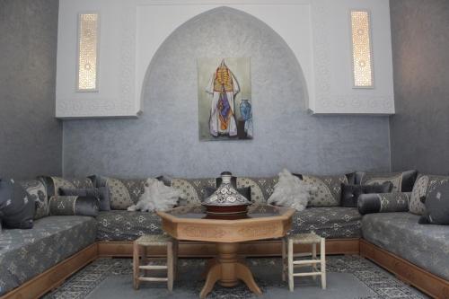 een woonkamer met een bank en een tafel bij Riad Darnooz in Marrakesh