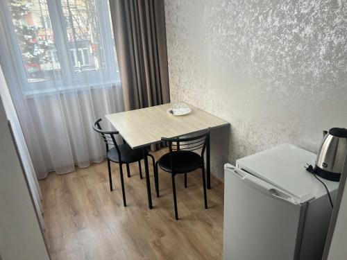 a small table and chairs in a small room at Готель «У Батька» in Truskavets