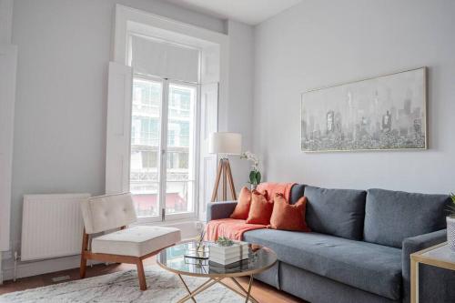 a living room with a blue couch and a table at Stylish Flat in the heart of South Kensington in London