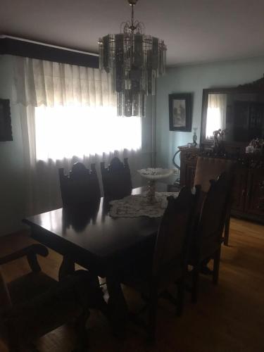 a dining room with a table and chairs and a window at Vila Ana Ipatescu in Craiova