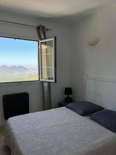 une chambre avec un lit et une grande fenêtre dans l'établissement Maison 4 Pers - Vue mer et vignoble exceptionnelle, à Poggio-dʼOletta