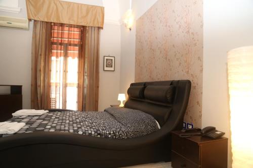 1 dormitorio con cama negra y ventana en Nuovo Hotel Sangiuliano en Catania
