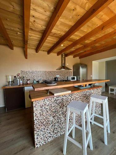 - une cuisine avec un comptoir et deux tabourets dans l'établissement Maison 4 Pers - Vue mer et vignoble exceptionnelle, à Poggio-dʼOletta