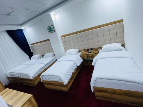 a small room with three beds in it at Danzha Motel Erbil in Erbil