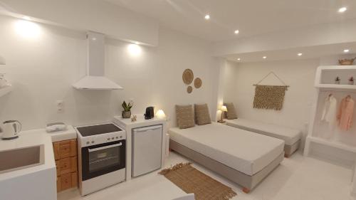 Biały pokój z łóżkiem i kuchnią w obiekcie Evdion Naxos Town w mieście Naksos