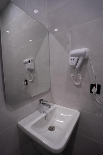 a bathroom with a sink and a mirror at Danzha Motel Erbil in Erbil