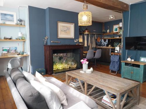 a living room with a couch and a table and a fireplace at La Cabane du Pecheur in Honfleur