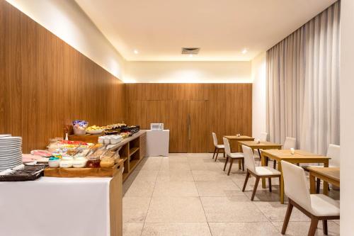 un restaurante con paredes de madera, mesas y sillas en Ramada by Wyndham Brasilia Alvorada en Brasilia