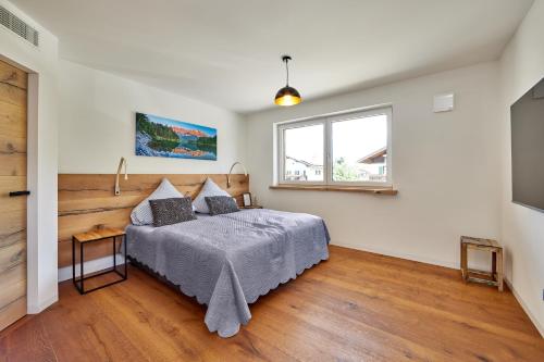 a bedroom with a bed and a window at Sunshine Apartment Wood'n Rustic in Garmisch-Partenkirchen