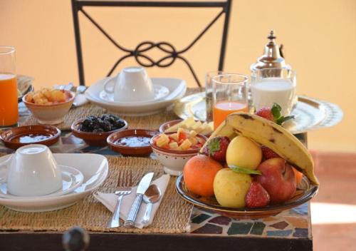 a table topped with a plate of fruit and juice at RIAD DAR WINK in Marrakesh