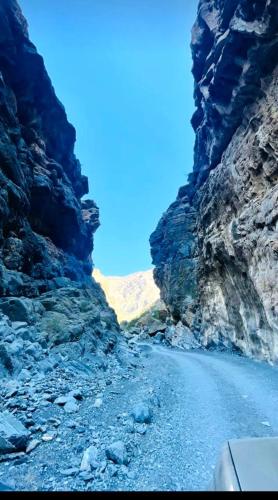 a car driving through a canyon on a road at Sunset view hill jabal shams in Misfāh