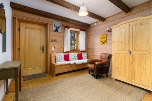 a living room with a couch and a chair in a room at Ski-in & Ski-out out Chalet Maria with amazing mountain view in Maria Alm am Steinernen Meer